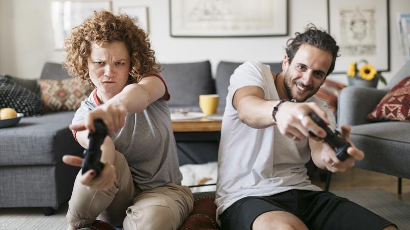 Pai e filho jogam com comandos numa sala